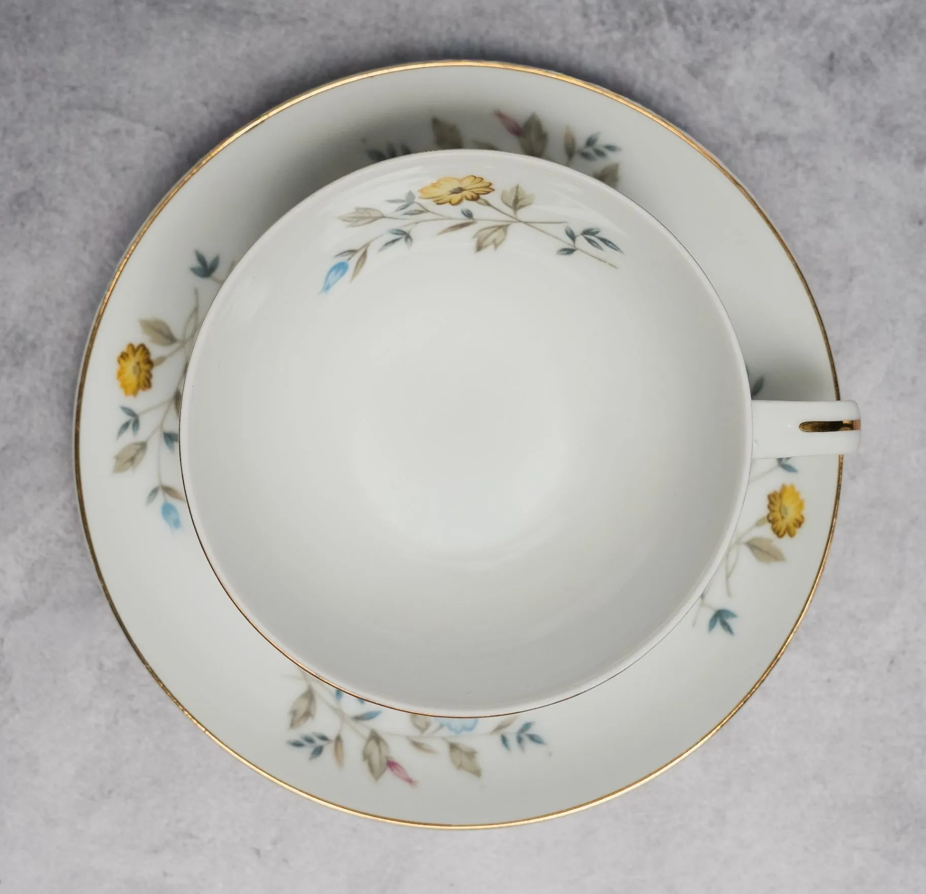 Photograph of Grandma Ada’s white floral teacup and matching saucer with a fine gold rim