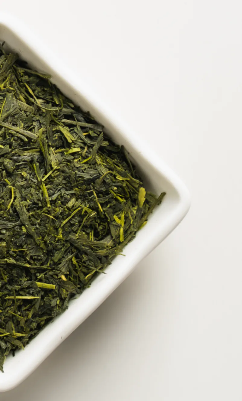 Sakura Kaori loose-leaf green tea in a white porcelain dish on a clean white background.